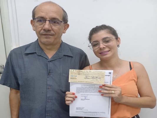 Fernando Cesar da Costa repassa cheque à representante da Prefeitura, Ana Paula S. Amaral